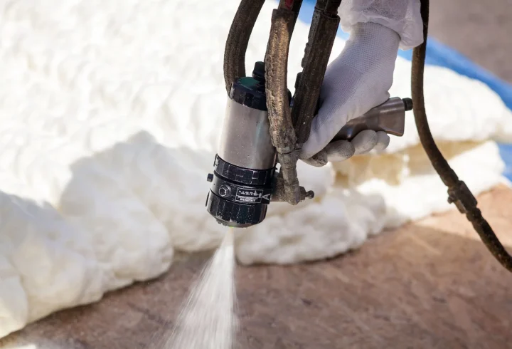 Spray gun spraying foam insulation