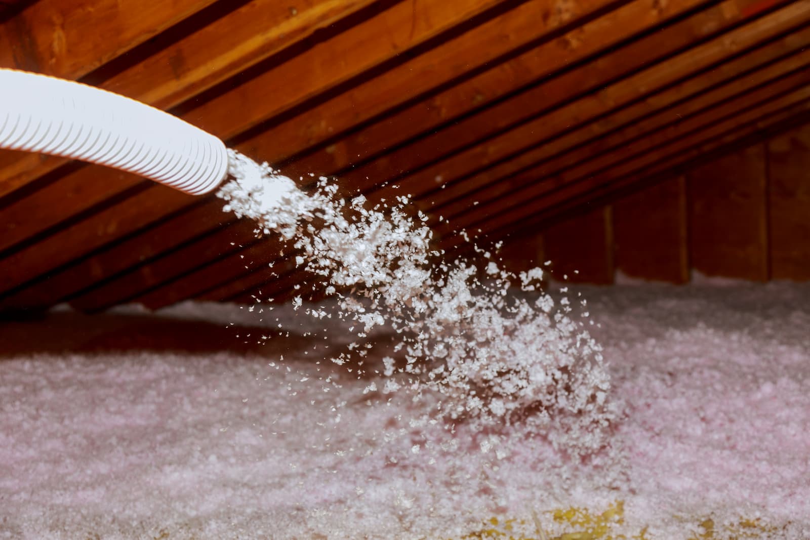 Spraying blown fiberglass insulation for roof tech