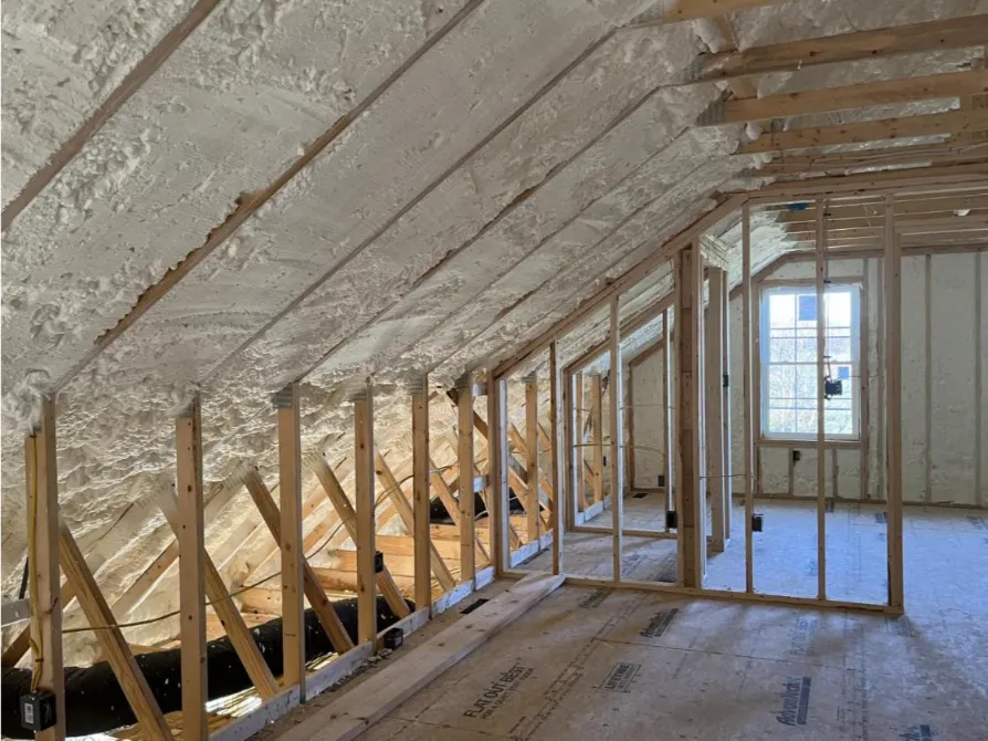 Attic under construction with spray foam insulation applied.